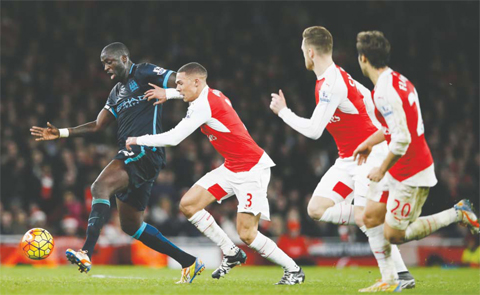 LONDON: Manchester City’s Yaya Toure, left attempts to get past Arsenal’s Kieran Gibbs during the English Premier League soccer match between Arsenal and Manchester City at the Emirates stadium in London, Monday. — AP