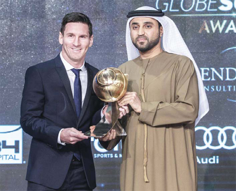 DUBAI: Barcelona striker Lionel Messi receiving the trophy for best player of the year during the Dubai Globe Soccer award at the end of the Dubai International Sports Conference on Sunday. — AFP