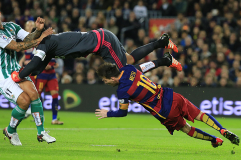 BARCELONA: Real Betis' goalkeeper Antonio Adan (up) hits Barcelona's Argentinean forward Lionel Messi during the Spanish league football match FC Barcelona vs Real Betis Balompie at the Camp Nou stadium in Barcelona on December 30, 2015. - AFP 