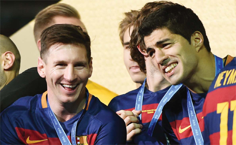 YOKOHAMA: Barcelona forward Lionel Messi (L) smiles beside forward Luis Suarez (R) on the podium during the awarding ceremony after winning the Club World Cup football final against River Plate in Yokohama on Sunday. — AFP