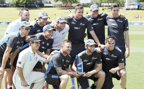 HAMILTON: New Zealand players pose with the trophy after they defeated Sri Lanka by 5 wickets on the fourth day of the second international cricket test in Hamilton, New Zealand, yesterday. —AP