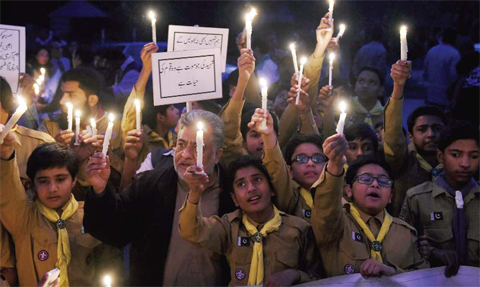 LAHORE: Pakistani teachers and students hold burning candles during a vigil to pay tribute to the victims of the Peshawar school massacre of December 16, 2014, the deadliest terror attack in Pakistan’s history, ahead of the first anniversary. — AFP