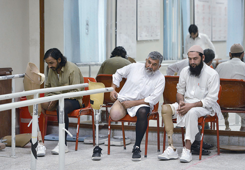 PESHAWAR: Pakistani improvised explosive device (IED) victims sit at the Pakistan Institute of Prosthetic and Orthotic Sciences (PIPOS) in Peshawar. —AFP