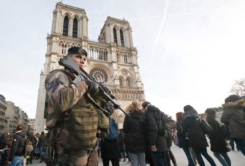 PARIS: A soldier patrols at the Notre Dame cathedral. France's defense minister has visited troops on duty ahead of unusually tense New Year's Eve celebrations in Paris. - AP