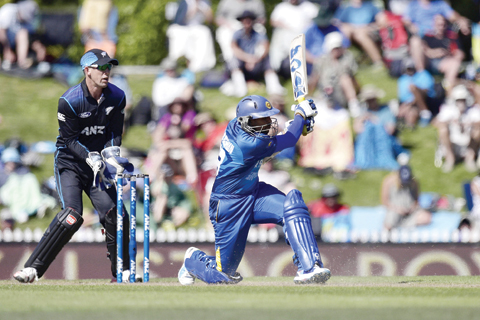NELSON: Tillakaratne Dilshan (R) of Sri Lanka plays a shot in front of New Zealand wicketkeeper Luke Ronchi during the 3rd One Day International cricket match between New Zealand and Sri Lanka at Saxton Oval in Nelson yesterday. -- AFP 