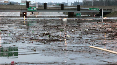 ST LOUIS: File photo shows water swells on Highway 141, underneath a closed Interstate 44 overpass in Fenton, Mo, a suburb of St Louis. — AP photos