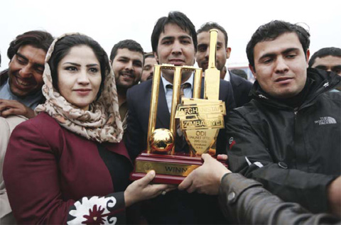 Afghans hold a trophy as they celebrate the victory of the national cricket team over Zimbabwe as the team returns and celebrates in Kabul, Afghanistan, yesterday. Afghanistan’s national cricket team returned home victorious Monday after securing their second Twenty20 win over Zimbabwe in three months in a compelling series that propelled the Afghans into the world top ten in both the one-day and T20 formats. — AP