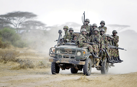 FILE - In this Monday, Feb. 20, 2012 file photo, Kenyan army soldiers ride on a vehicle at their base in Tabda, inside Somalia. Heavily armed fighters from the Islamic extremist group al-Shabab attacked a base for African Union peacekeepers in southwestern Somalia on Friday, Jan. 15, 2016, blasting their way into the compound and exchanging fire with peacekeepers, a Somali military official said. (AP Photo/Ben Curtis, File)
