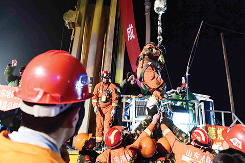 The first miner, centre on hoist,  is lifted from a collapsed mine in Pingyi, east China's Shandong Province, Friday evening Jan. 29, 2016. Chinese state media say two miners have been rescued from a collapsed mine after spending 36 days trapped underground. Efforts continued Friday to reach the remaining two people in the mine in east China's Shandong province. The gypsum mine collapsed on Christmas Day, killing one and leaving 13 others missing. In the days that followed, rescuers detected four survivors 200 meters (660 feet) below the surface. (Guo Xulei/Xinhua via AP)  CHINA OUT