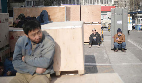 BEIJING: A group of workers rest outside a securities company in Beijing yesterday. China logged its worst economic performance since the global financial crisis in the third quarter of 2015, with gross domestic product (GDP) rising just 6.9 percent its lowest rate in six years. —AFP