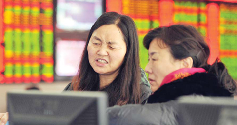 SHANGHAI: Two investors chat in a stock firm in Fuyang, east China’s Anhui province yesterday. Trading on the Shanghai and Shenzhen stock exchanges was ended early yesterday after shares fell seven percent, the first time China’s new “circuit breaker” intervened to curb market volatility. — AFP