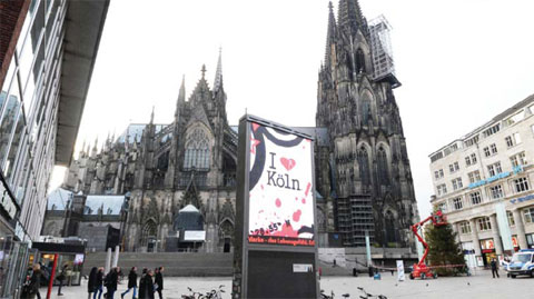 COLOGNE: A poster promoting the city of Cologne can be seen in front of the western city’s landmark, the Cologne Cathedral, near the main railway station yesterday. Police in the western city told AFP they have received more than 100 complaints by women reporting assaults ranging from groping to rapes, allegedly committed in a large crowd of revellers during year-end festivities outside the city’s main train station and its famed Gothic cathedral. — AFP