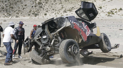 BELEN: Peugeot’s French driver Sebastien Loeb is helped to put his overturned car back on its wheels during Stage 8 of the Dakar 2016 between Salta and Belen, Argentina, on Monday. — AFP