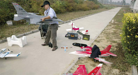 BEIJING: In this Oct. 17, 2015 photo, a drone-flying aficionado prepares his model aircrafts for flight on the outskirts of Beijing. Even as drones offer law enforcement sharply expanded capabilities, authorities in China, as in many other countries, are scrambling to regulate their use. The country is now beginning to set nationwide regulations, which are applauded by many in the Chinese industry. — AP