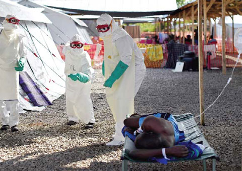KENEMA, Sierra Leone: This file photo taken on November 15, 2014 shows health workers wearing protective equipment dance as they try to cheer up an Ebola patient at Kenama treatment center run by the Red cross Society on November 15, 2014. — AFP