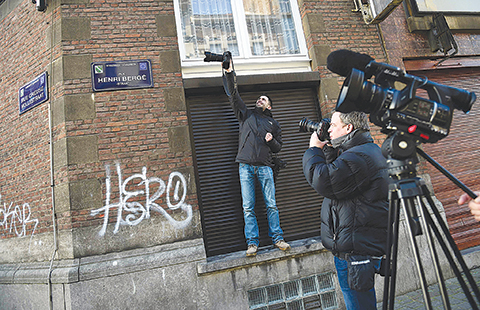 A picture taken on January 8, 2016 in the Brussels district of Schaerbeek shows journalists taking pictures in  the Rue Henri Berge. Belgian police have found three belts for possible use in suicide attacks, traces of explosives and a fingerprint of wanted Paris attacks suspect Salah Abdeslam, prosecutors said. The discovery was made in December during a search of an apartment in the Schaerbeek area of the Belgian capital. It was rented by someone using a false name, possibly used by another suspect now in custody, they said. - -n / AFP / EMMANUEL DUNAND / -