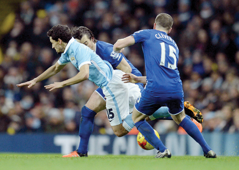 MANCHESTER: Everton's English defender Leighton Baines (L) and Everton's English midfielder Tom Cleverley (R) vies with Manchester City's Spanish midfielder Jesus Navas during the English League Cup semi-final second leg football match between Manchester City and Everton the Etihad Stadium in Manchester, north west England, on Wednesday. - AFPn