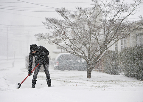 Sofia Garcia shovels the sidewalks in front of her house as snow falls, Friday morning, Jan. 22, 2016, in Lynchburg, Va. (Jill Nance/News &amp; Daily Advance via AP) MANDATORY CREDIT