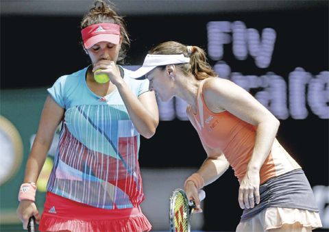 MELBOURNE: Martina Hingis, right, of Switzerland and Sania Mirza of India talk during their fourth round match against Anna-Lena Groenefeld of Germany and Coco Vandeweghe of the United States at the Australian Open tennis championships in Melbourne, Australia, yeserday. — AP