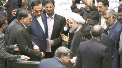 TEHRAN: Iranian President Hassan Rouhani, center, gestures as he is greeted by lawmakers at the parliament to present draft of the country’s next year budget and sixth development plan in Tehran yesterday. — AP