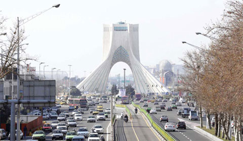 TEHRAN: Vehicles driving on a street in front of the Azadi Tower in the capital Tehran yesterday. — AFP