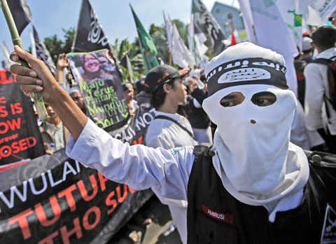 SURABAYA: In this June 18, 2014, file photo, a man wears a headband showing the Islamic State group’s symbol during a protest calling for the closure of a local prostitution complex. Experts say it is difficult to know how much of a foothold the Islamic State group has established in Indonesia. — AP