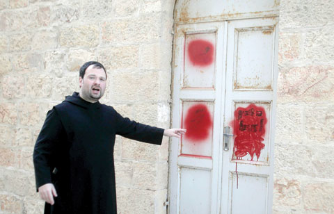 JERUSALEM: Father Nikodemus Schnabel spokesperson of the Dormition Abbey points towards anti-Christian graffiti in Hebrew, daubed on the Church of the Dormition, one of Jerusalem’s leading pilgrimage sites. — AFP