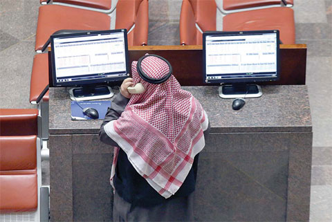 KUWAIT: A stock trader makes a phone call as he monitors the share prices at Kuwait Stock Exchange. The KSE indices edged lower yesterday amid bearish trends across the world