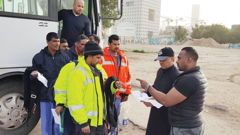 KUWAIT: Plainclothes detectives check the documents of workers during a sudden raid at the Sharq fish market yesterday, which resulted in the arrest of 34 residency law violators.