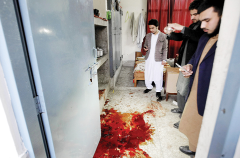 CHARSADDA, Pakistan: Pakistani students look at a pool of blood following an attack at Bacha Khan University outside the city of Peshawar yesterday. — AP