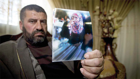 NABLUS: Ramiz Hassoneh holds a photo of his daughter, Maram, in the West Bank city of Nablus. Maram, a top English student at An-Najah University and a devout Muslim, was shot and killed when she tried to stab Israeli soldiers at a West Bank checkpoint. —AP