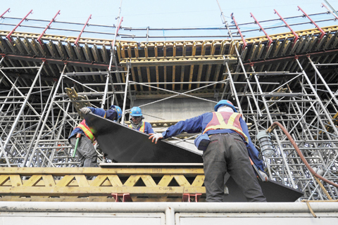 MANILA: Construction personnel work beside scaffolding on a government elevated highway project in Manila yesterday. Philippine economic growth accelerated in the final quarter of 2015, boosted by a burst in government spending, but fell short of the official full-year target. -- AFP n