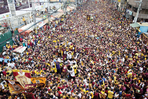 MANILA: Devotees join the annual procession with the religious icon of the Black Nazarene (center) in Manila yesterday. _ AFP n