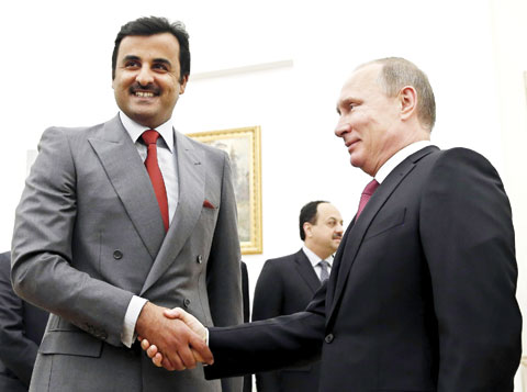 Russian President Vladimir Putin shakes hands with Qatari Emir Sheikh Tamim bin Hamad Al-Thani during a meeting at the Kremlin in Moscow