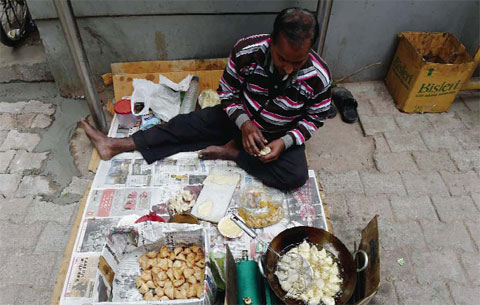 NEW DELHI: An Indian vendor prepares samosas at a roadside stall. — AFP