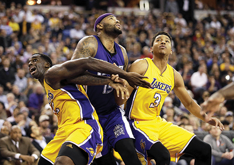 Los Angeles Lakers forward Brandon Bass, left, and guard Anthony Brown, right, battle for a rebound with Sacramento Kings center DeMarcus Cousins during the second half of an NBA basketball game in Sacramento, Calif., Thursday, Jan. 7, 2016. The Kings won 118-115 (AP Photo/Carl Costas)