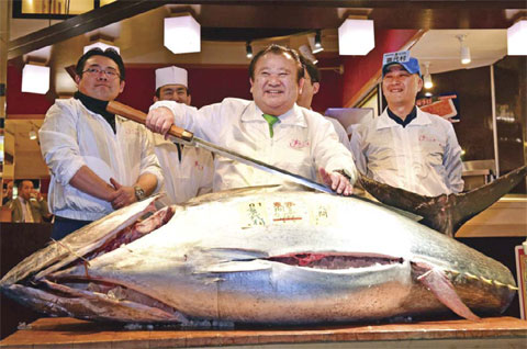 TOKYO: President of sushi restaurant chain Sushi-Zanmai, Kiyoshi Kimura, displays a 200kg bluefin tuna at his main restaurant near Tokyo’s Tsukiji fish market yesterday. — AFP photos