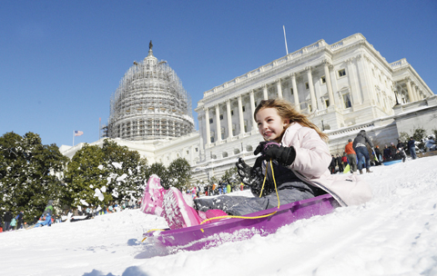 WASHINGTON: A young girl slides on the West Lawn of the US Capitol on Monday. —AFP