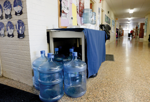 NEW YORK: Bottles of drinking water are seen in a hallway at St Mary’s Academy in Hoosick Falls, NY. Federal regulators have warned residents of the upstate New York factory village near the Vermont border not to drink water from municipal wells. — AP