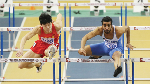 DOHA: Kuwait's Abdulazeez Al-Mandeel (R) and China's Yufei Hu compete in the men's 60m hurdles event during the seventh Asian Indoor Athletics Championships at the Aspire Academy of Sports in the Qatari capital, Doha, yesterday. – AFP