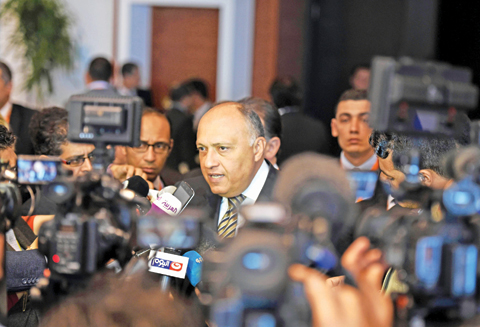SHARM EL-SHEIKH: Egyptian Foreign Minister Sameh Shoukry speaks to the media during the “Africa 2016” conference in the Red Sea resort of Sharm El-Sheikh yesterday. More than 1,200 delegates including some heads of state are attending talks to sign business agreements during the two-day summit, aimed at attracting private sector investment. (Right) A man attends the “Africa 2016” conference. — AFP