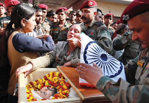 UDHAMPUR: The mother of Indian Army Captain Tushar Mahajan cries next the coffin of his son before performing last rites in Udhampur yesterday.—AP