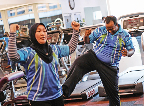 KUALA LUMPUR: Malaysian police officer Suresh Mariah (right) exercising with others as he takes part in the special weight-loss and fitness program “Trim and Fit” at police headquarters in Kuala Lumpur.