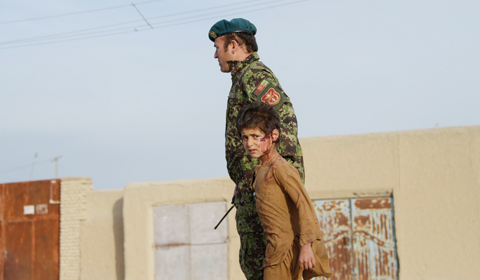 DEHDADI: A wounded Afghan boy walks with an Afghan National Army (ANA) soldier at the site of a suicide attack in a district close to the provincial capital Mazar-i- Sharif. — AFP
