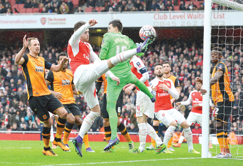 LONDON: Arsenal's English defender Calum Chambers (C) tries to shoot past Hull City's Swiss goalkeeper Eldin Jakupovic (3R) during the FA cup fifth round football match between Arsenal and Hull City at the Emirates Stadium in London yesterday. - AFP