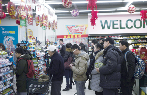 BEIJING: Customers queue up at the check out line at a supermarket in Beijing yesterday. Chinese trade slumped in January, authorities said as both exports and imports tumbled with feeble domestic and global demand dragging on the world’s second-largest economy. —AFP