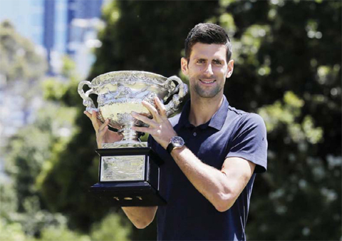 MELBOURNE: Serbia’s Novak Djokovic poses for photos with his Australian Open trophy at Government House in Melbourne, Australia, yesterday. Djokovic defeated Britain’s Andy Murray in the men’s final at the Australian Open tennis championships on Sunday.— AP