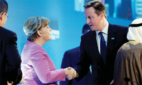LONDON: German Chancellor Angela Merkel shakes hands with Prime Minister David Cameron, (right) at the ‘Supporting Syria and the Region’ conference at the Queen Elizabeth II Conference Centre in London yesterday. —AP