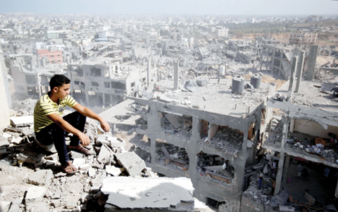GAZA: A Palestinian man looks out over destruction in part of Gaza City’s Al-Tufah neighborhood in this file photo. — AFP