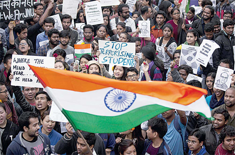 NEW DELHI: Indian students wave Indian flags and shout slogans during a protest at the Jawaharlal Nehru University against the arrest of a student union leader in New Delhi, India. —AP